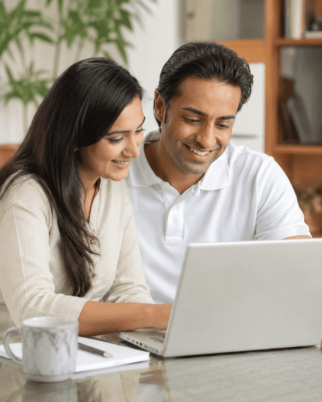 Two parents happily reviewing their childโs learning progress together on a laptop